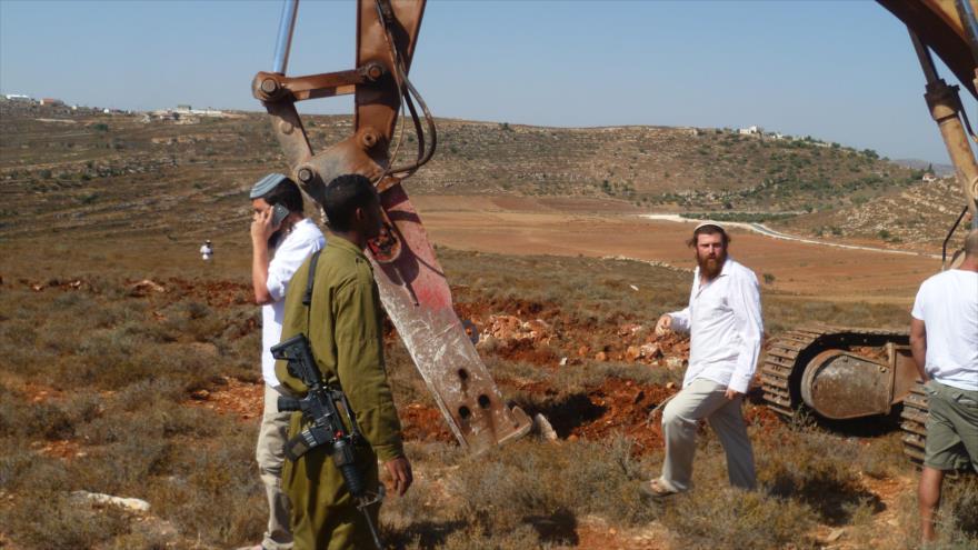 Colonos israelíes, respaldados por las fuerzas israelíes, interrumpen el trabajo de los palestinos en la preparación de la tierra para el cultivo en la aldea de Qusra, en Nablus.