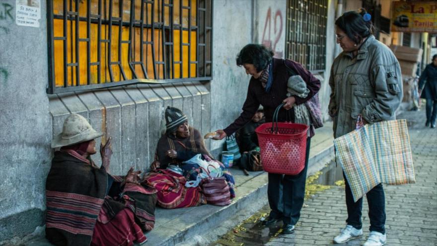 Dos voluntarias bolivianas reparten alimento a las mujeres pobres.