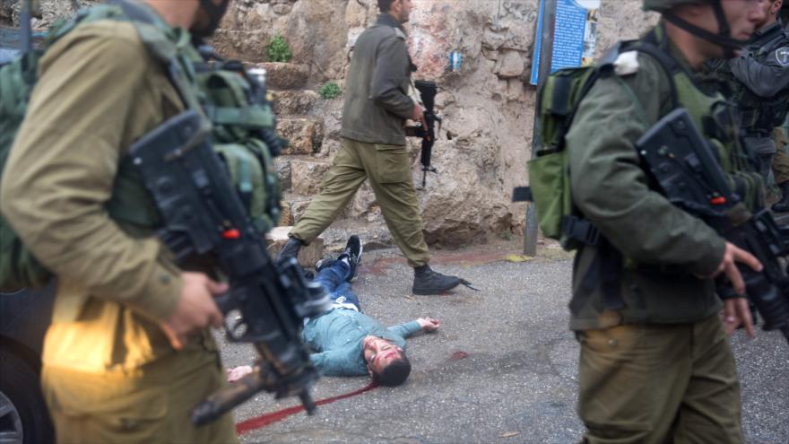 Fuerzas israelíes rodean el cuerpo de un palestino asesinado en Al-Jalil (Hebrón), 29 de octubre de 2015.