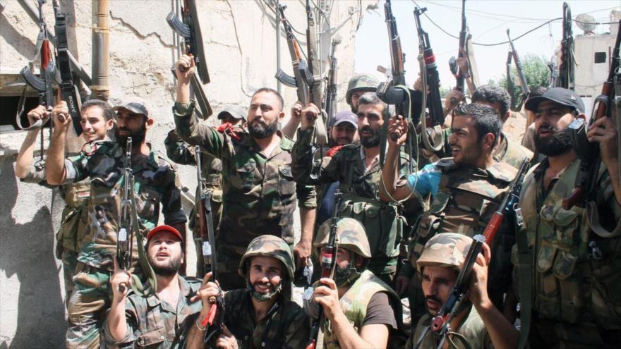 Soldados del Ejército sirio alzan armas tras su avance ante grupos terroristas en el barrio de Jober en la capitalina ciudad de Damasco.