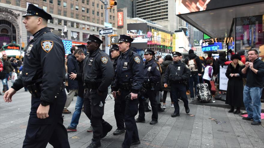 Agentes de la Policía de Nueva York, noreste de EE.UU., caminan entre la multitud en la intersección de Times Square, el 31 de diciembre 2015, para garantizar la seguridad durante la Nochevieja.