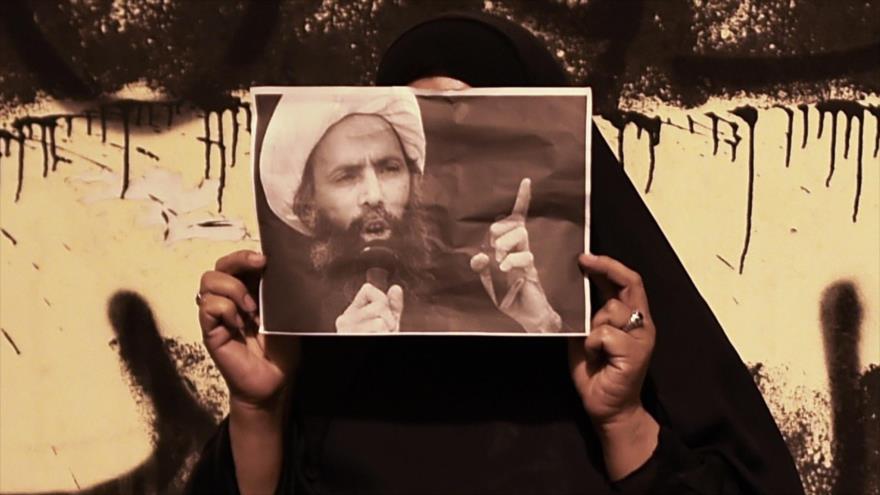 Una mujer porta la foto del clérigo chií el sheij Nimr Baqer al-Nimr durante una manifestación para pedir su liberación.