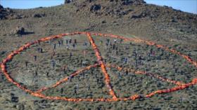 Forman símbolo de paz con chalecos salvavidas de refugiados en Grecia