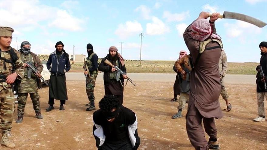 Un integrante del grupo terrorista Daesh lleva a cabo una decapitación.