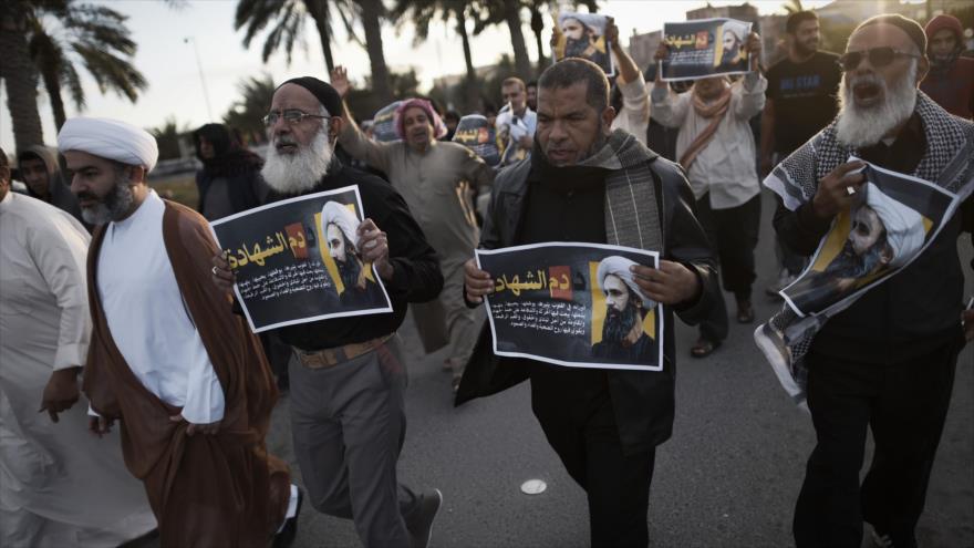 Manifestantes bareiníes sostienen fotos del prominente clérigo chií, el sheij Nimr Baqer al-Nimr, en una protesta contra su ejecución en Jidhafs, al oeste de Manama (capital de Baréin). 3 de enero de 2016