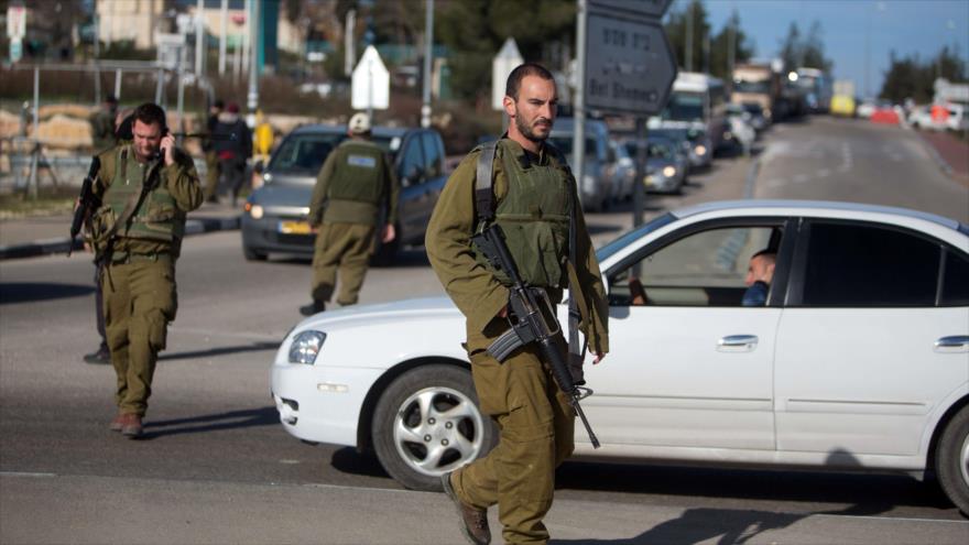 Soldados israelíes revisan el tráfico de vehículos cerca de asentamientos ilegales de Gush Etzion, situados en Cisjordania.