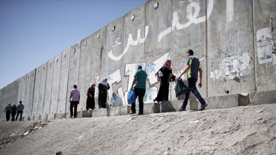 Los palestinos caminan cerca del llamado muro de separación (el Muro de Apartheid) en la ocupada Cisjordania.