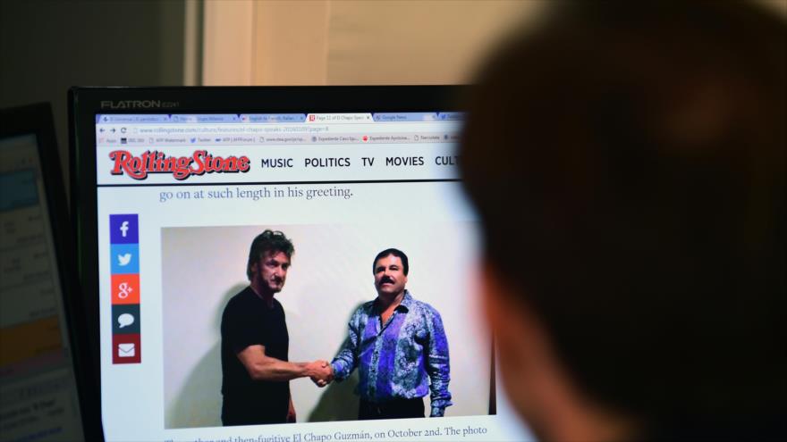 Una persona lee un artículo sobre el narcotraficante Joaquín Guzmán, alias "El Chapo", en el que se ve una foto de él (dcha.) y del actor estadounidense Sean Penn, en la página web de la revista Rolling Stone, en la Ciudad de México, el 10 de enero de 2016.