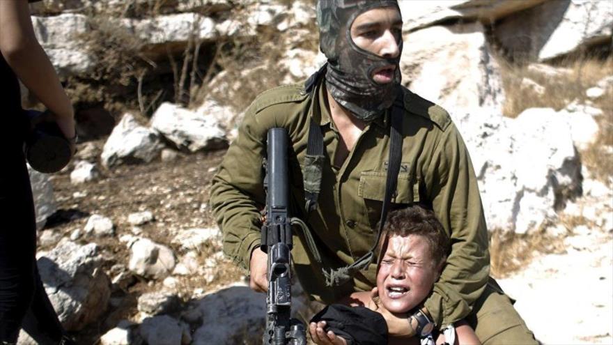 Un soldado israelí detiene a un niño palestino durante una protesta en la aldea cisjordana de Nabi Saleh.