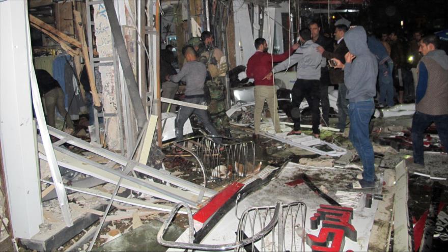 Ciudadanos iraquíes reunidos en el sitio de un ataque contra un centro comercial en Bagdad, capital de Irak. 11 de enero de 2016