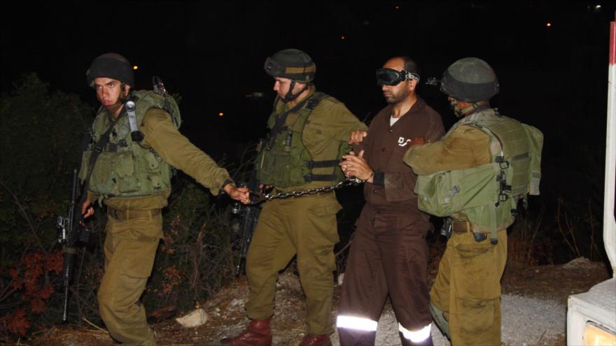 Soldados israelíes trasladan a un preso palestino.