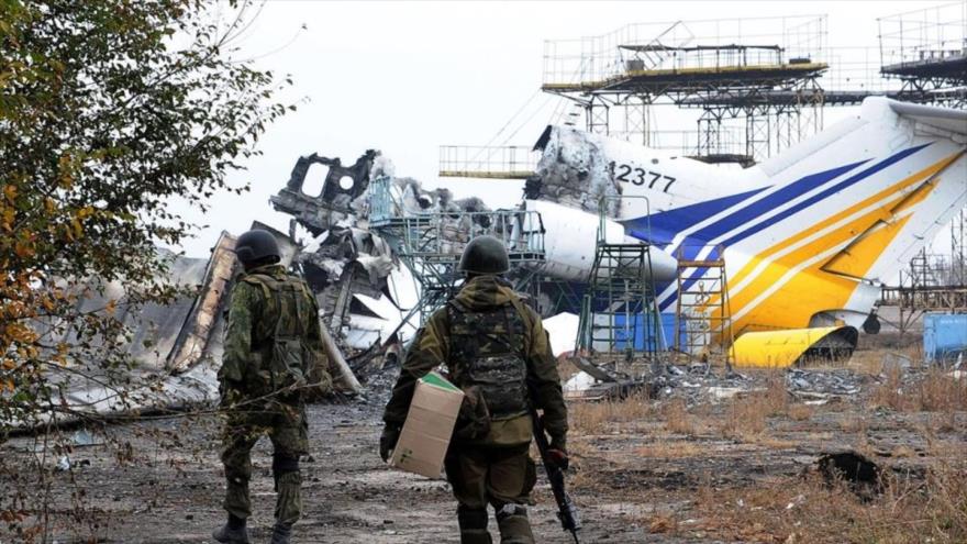 Milicias de Donetsk caminan cerca de un avión destruido en el aeropuerto internacional de Donetsk. 16 de octubre de 2014