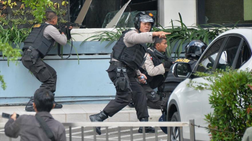 Agentes policiales indonesios toman posición durante operaciones para abatir a los sospechosos tras varias explosiones registradas en Yakarta, la capital de Indonesia, 14 de enero de 2016.