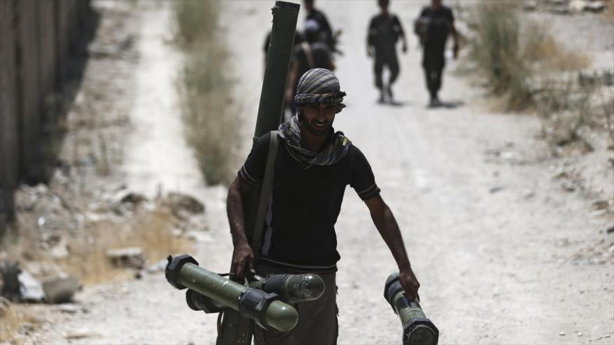 Un miembro de la legión Al-Rahman del llamado Ejército Libre Siria (ELS) porta varios cohetes.