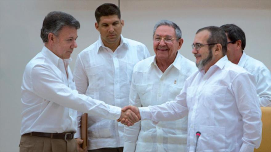 El máximo jefe de las FARC, Rodrigo Londoño Echeverri (dcha.), y el presidente colombiano, Juan Manuel Santos (izqda.), acompañado del presidente cubano, Raul Castro (c), 23 de septiembre de 2015.