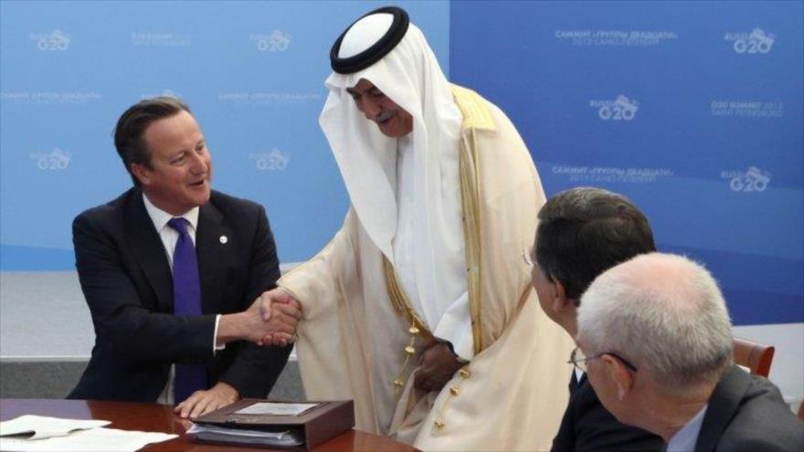 El primer ministro del Reino Unido, David Cameron (izda) estrecha la mano al ministro saudí de Finanzas, Ibrahim Abdulaziz Al-Assaf.