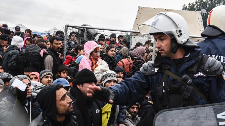 Migrantes y refugiados esperan para cruzar la frontera entre Grecia y Macedonia, cerca de la ciudad de Gevgelija, 4 de diciembre de 2015.