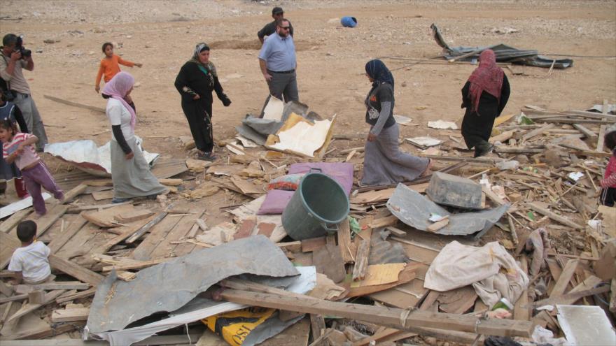 Beduinos palestinos recogen el resto de sus bienes tras la demolición de su casa por fuerzas israelíes.