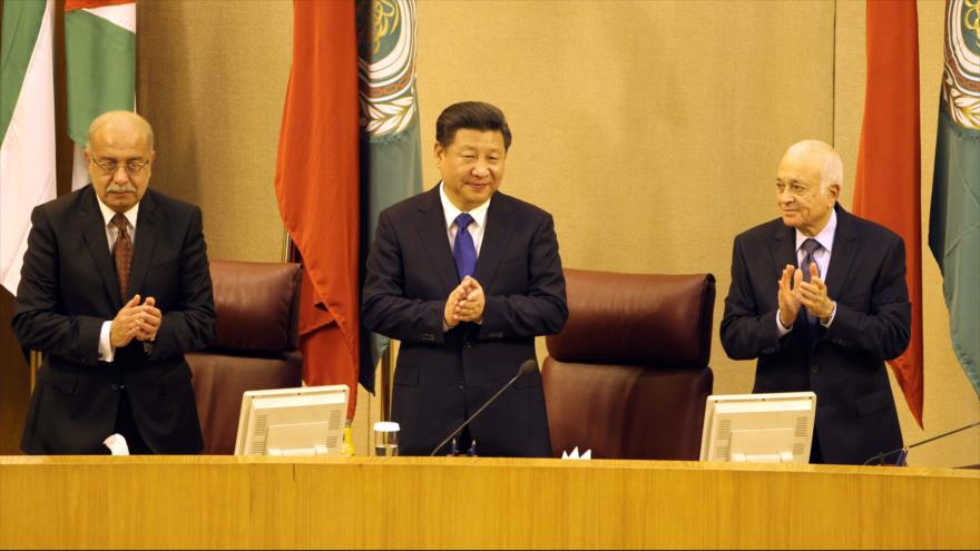 El presidente chino, Xi Jinping (centro), flanqueado por el premier de Egipto, Sharif Ismail (izda.) y el secretario general de la Liga Árabe, Nabil al-Arabi, aplaude tras su llegada a la sede de la Liga, en El Cairo, capital egipcia. 21 de enero de 2016.