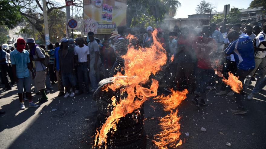 Manifestantes queman neumáticos durante una protesta en contra de la segunda vuelta presidencial en Puerto Príncipe (capital de Haití), 19 de enero de 2016.