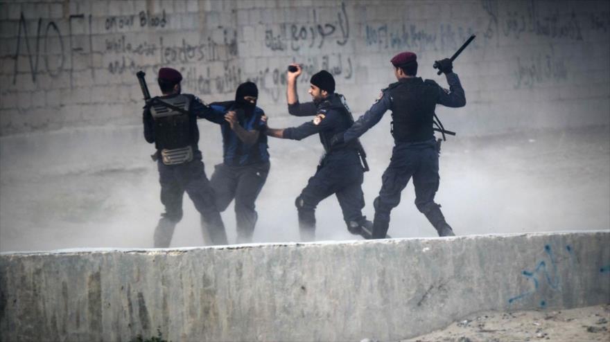 Fuerzas de la policía bareiní golpean con porras a un manifestante antigubernamental. 