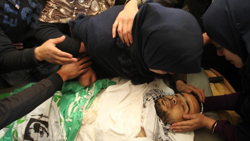 Madre de Mohamad Ahmad Kawazbeh, asesinado a tiros por las fuerzas israelíes, se despide de su hijo, en el pueblo de Sair, en Al-Jalil (Hebrón), 13 de enero de 2016.