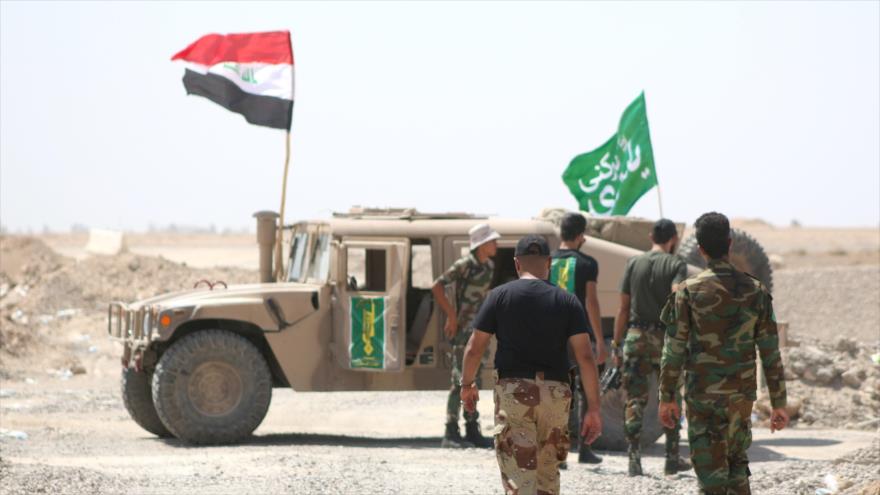 Combatientes iraquíes se dirigen a un vehículo militar durante una operación contra los takfiríes del EIIL (Daesh, en árabe) desde un camino que conduce hacia la aldea de Saqlawiya, en el norte de Faluya, en la provincia occidental iraquí de Al-Anbar. 19 de agosto de 2015.