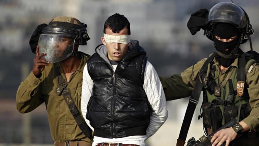 Soldados israelíes detienen a un joven palestino.