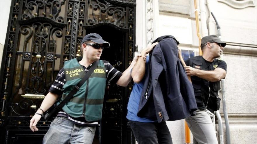 Dos agentes de la Guardia Civil española escoltan a un detenido durante el registro de la sede en Valencia de la empresa Estrategia de Identidad y Comunicación Online (EICO), creada por uno de los empresarios implicados en la operación Púnica, julio de 2015.