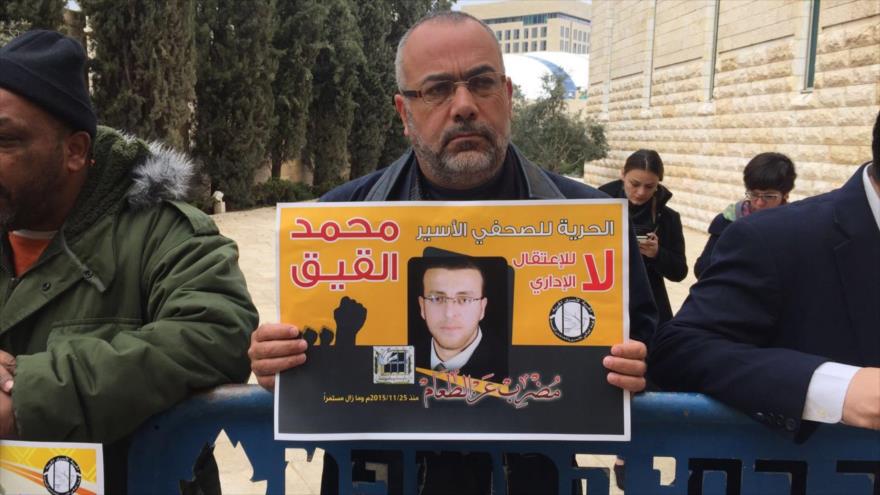 Manifestantes palestinos urgen la liberación del periodista palestino Mohamad al-Qiq.