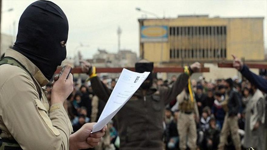 Un miembro del grupo terrorista EIIL (Daesh, en árabe) anuncia la sentencia de muerte de dos civiles en la provincia iraquí de Nínive (norte).