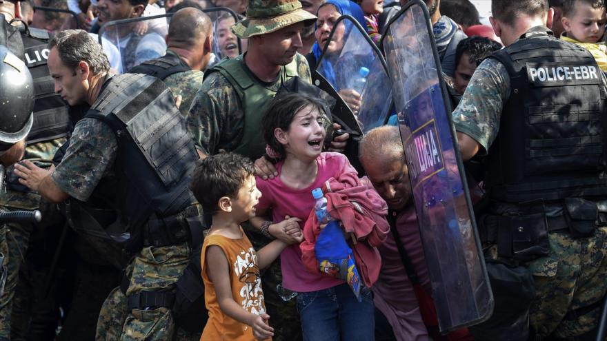 Dos niños lloran en la frontera de Macedonia en un enfrentamiento entre policías y refugiados.