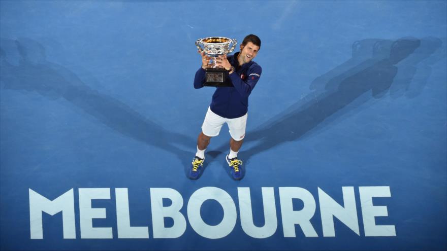 El tenista serbio Novak Djokovic levanta el trofeo de Abierto de Australia, 31 de enero de 2016.