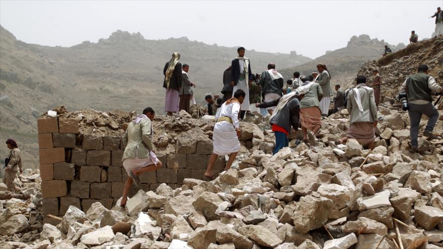 Yemeníes caminan sobre los escombros de sus viviendas destruidas en los ataques saudíes en el distrito de Bani Matar, al oeste de la ciudad capitalina de Saná, 4 de abril de 2015.