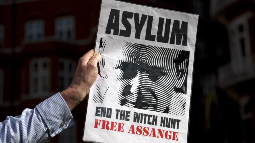 Un simpatizante del fundador de Wikileaks, Julian Assange, sostiene una pancarta frente a la embajada de Ecuador en Londres, donde el periodista australiano permanece asilado desde hace más de tres años, 19 de junio de 2015.