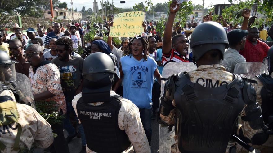 La policía haitiana se enfrenta a manifestantes durante una marcha en Puerto Príncipe (capital de Haití), en rechazo a la intervención mediadora de la OEA en la crisis electoral, 30 de enero de 2016.