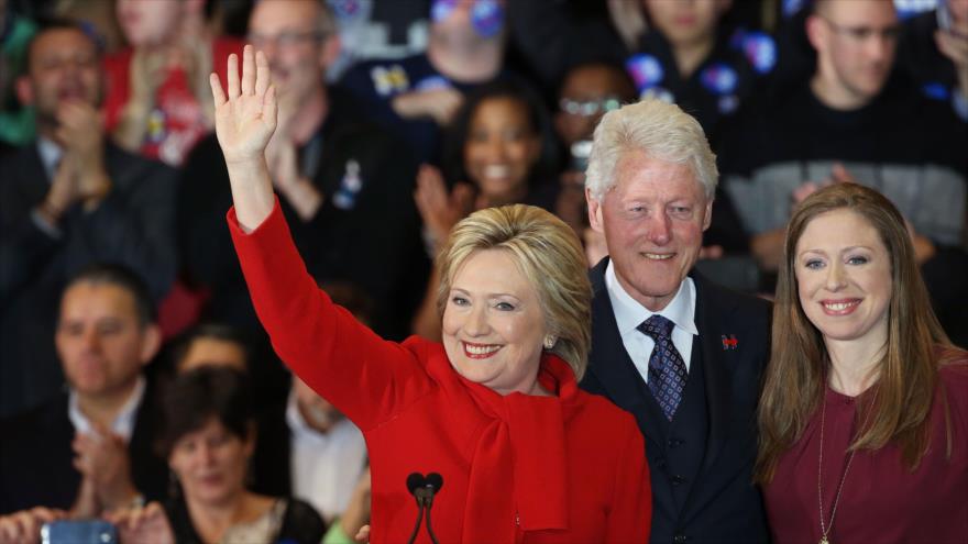 La precandidata demócrata a la presidencia de Estados Unidos, Hillary Clinton, saluda a sus simpatizantes junto a su marido, Bill Clinton, e hija, Chelsea Clinton, durante un evento en Des Moines, Iowa (centro), 1 de febrero de 2016. 