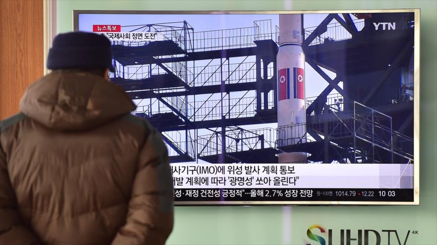 Un hombre ve un informe de prensa en la televisión sobre el lanzamiento de un cohete planeado por Corea del Norte.