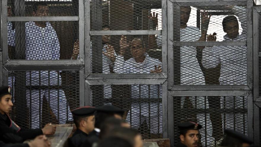 Egipcios miembros del movimiento de los Hermanos Musulmanes (HHMM), se encuentran tras las rejas en un juzgado en las afueras de la capital de Egipto, El Cairo.