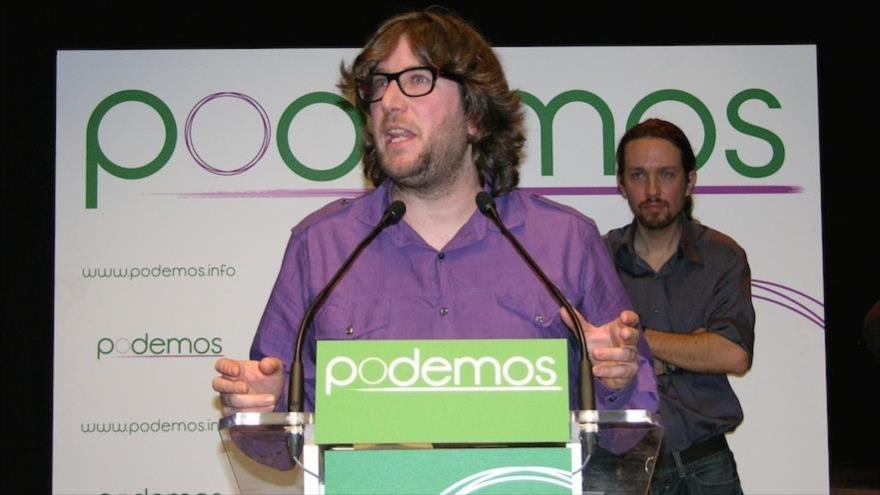 El eurodiputado de Podemos Miguel Urbán, en un acto del partido y bajo la atenta mirada del líder la formación morada, Pablo Iglesias, que se encuentra en un segundo plano.