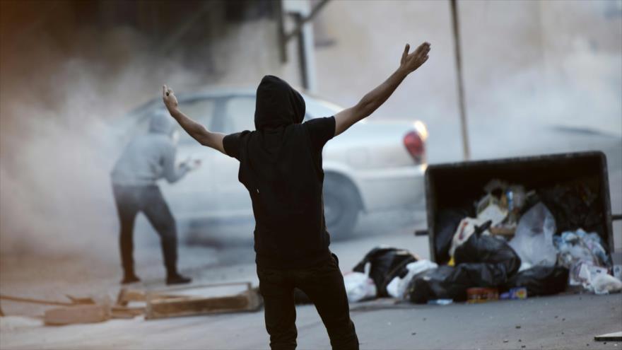 Los manifestantes bareiníes resisten ante gases lacrimógenos lanzados por fuerzas de seguridad bareiníes, 12 de febrero de 2016.