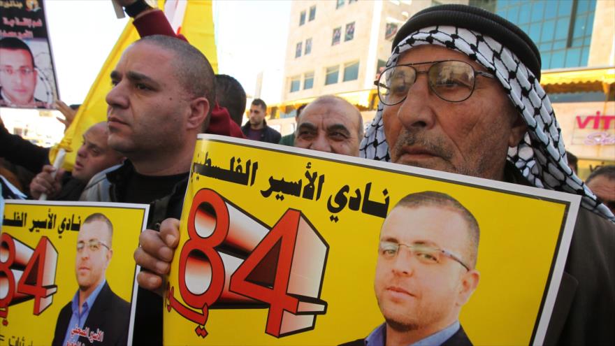 Palestinos participan en una manifestación para pedir la liberación de Mohamad al-Qiq, un periodista palestino en huelga de hambre por su detención arbitraria, en la ciudad cisjordana de Al-Jalil (Hebrón), 16 de febrero de 2016.