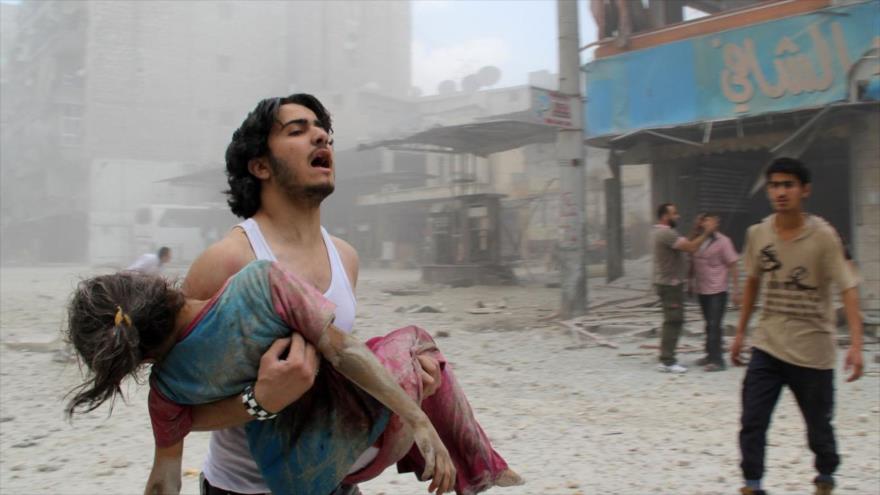 Un ciudadano sirio porta el cuerpo sin vida de una menor.