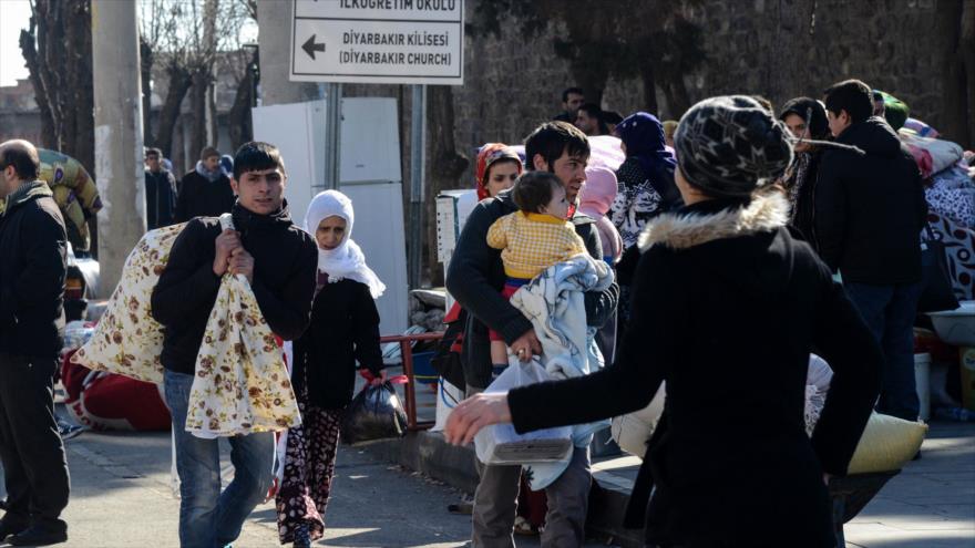 Residentes kurdos huyen con algunas de sus pertenencias después de nuevos toques de queda impuestos por las autoridades turcas en el distrito de Diyarbakir al sureste de Turquía. 27 de enero de 2016