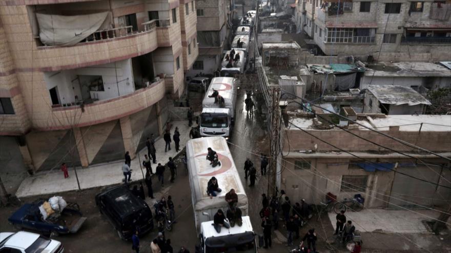 Un convoy de la Media Luna Roja con ayuda humanitaria de la ONU llega en una zona controlada por grupos terroristas, en las afueras de la capital siria de Damasco, 23 de febrero de 2016. 