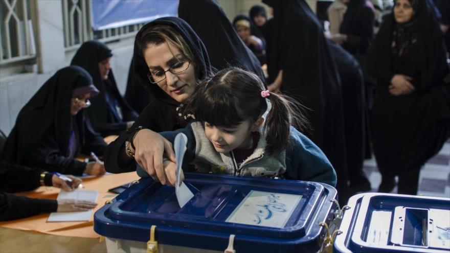 Una madre iraní ayudando a su hija para que deposite su voto en la urna. 26 de febrero de 2016