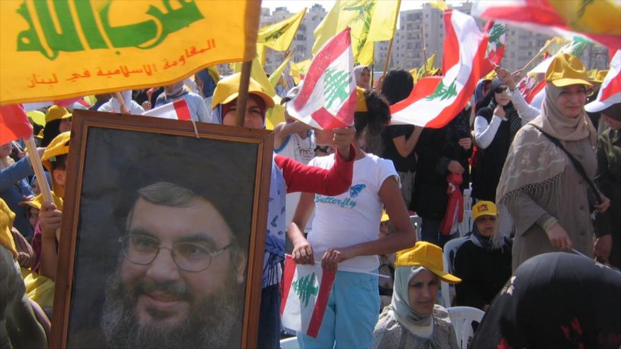 Manifestantes portan las banderas de Hezbolá y la imagen de su lider, Seyed Hasan Nasrolá, en una marcha en Beirut.