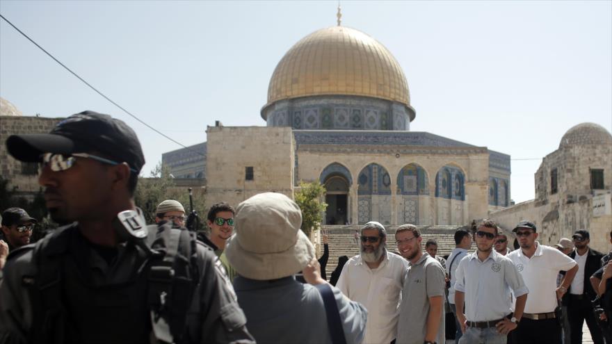 Colonos israelíes, acompañados por fuerzas del régimen de Tel Aviv, sacan fotos en el recinto de la Mezquita Al-Aqsa en Al-Quds (Jerusalén), 28 de julio de 2015.