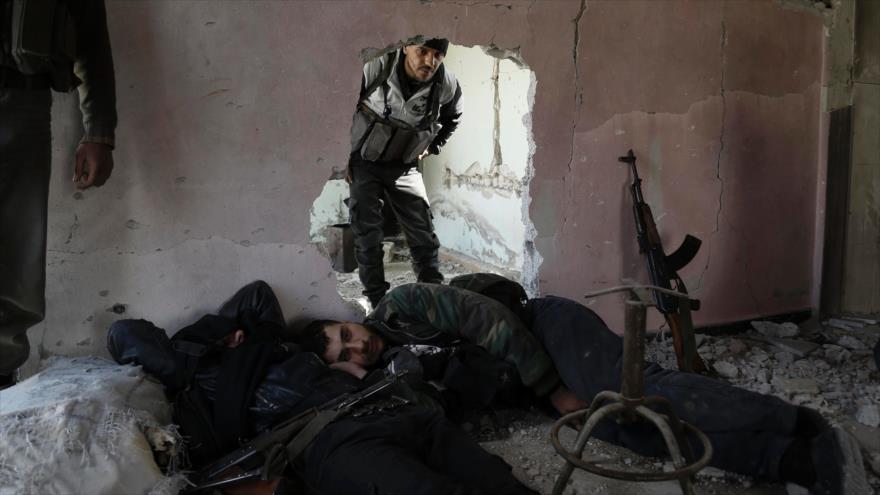 Los llamados combatientes rebeldes de Siria, de la brigada de Faylaq al-Rahman, se esconden dentro de un edificio en la región de Guta, cerca de Damasco (capital), en la segunda día de tregua, 28 de febrero de 2016.