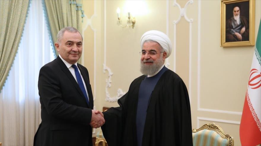 El presidente iraní, Hasan Rohani (dcha.), y el canciller rumano, Lazar Comanescu, se estrechan la mano durante un encuentro en Teherán, capital iraní. 1 de marzo de 2016